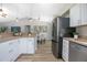 Open kitchen with white cabinets and stainless steel appliances overlooking the dining area at 597 Gainsboro St, Deltona, FL 32725