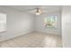 Bright bedroom featuring tile floors, ceiling fan, and a window for natural light at 678 Wellington Station Blvd # 54, Ormond Beach, FL 32174
