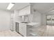 Bright kitchen and living room area features sleek white cabinets and stainless steel appliances at 678 Wellington Station Blvd # 54, Ormond Beach, FL 32174