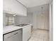 Bright kitchen and living room area features sleek white cabinets and stainless steel appliances at 678 Wellington Station Blvd # 54, Ormond Beach, FL 32174