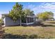 Fenced backyard with large trees, a lawn, and screened-in porch and a house with grey siding at 723 Pelican Ct, Kissimmee, FL 34759