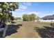 Spacious fenced backyard with a large lawn, trees, a screened porch and a house with grey siding at 723 Pelican Ct, Kissimmee, FL 34759