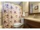 Bathroom featuring a vanity with dark wood cabinets and a shower/tub with floral curtain at 723 Pelican Ct, Kissimmee, FL 34759