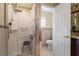 Bathroom with a shower featuring accessibility seating, handrails, and a toilet at 723 Pelican Ct, Kissimmee, FL 34759