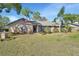 Charming single-story brick home featuring a well-manicured lawn, front flower beds and an American flag at 725 Briarcrest Dr, Orange City, FL 32763