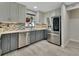 Well-lit kitchen with stainless steel appliances, stylish backsplash, and two-tone cabinets at 725 Briarcrest Dr, Orange City, FL 32763