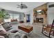 Spacious living room features a brick fireplace, ceiling fan, and wood look floors at 725 Briarcrest Dr, Orange City, FL 32763