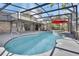 A screened-in pool features an attached spa, bright blue water, a gray deck, and a covered lanai at 725 Briarcrest Dr, Orange City, FL 32763