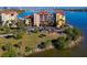 Aerial view of the waterfront condominiums featuring a well-maintained lawn with palm trees and easy parking at 732 Marina Point Dr # 7320, Daytona Beach, FL 32114