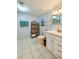 Bright bathroom with white tiled floors, a classic vanity, and ample storage space at 732 Marina Point Dr # 7320, Daytona Beach, FL 32114