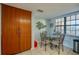 Dining area featuring a round glass-top table, wooden chairs, and a large storage cabinet at 732 Marina Point Dr # 7320, Daytona Beach, FL 32114