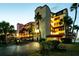 Exterior shot of a multi-story condominium building, featuring palm trees and evening illumination at 732 Marina Point Dr # 7320, Daytona Beach, FL 32114