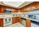 Cozy kitchen features wooden cabinets, modern appliances, and tiled backsplash at 732 Marina Point Dr # 7320, Daytona Beach, FL 32114