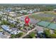 Aerial view of the home in a neighborhood with lush greenery and tennis courts at 852 Derbyshire Rd, Daytona Beach, FL 32117