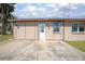 Close-up of the home's entrance, featuring a well-lit doorway and concrete patio at 852 Derbyshire Rd, Daytona Beach, FL 32117