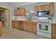 Bright kitchen featuring stainless steel appliances, ample wood cabinets, and tiled flooring at 3430 Arabesque Dr, Deland, FL 32724