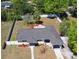 Aerial view of a quaint home featuring a fenced yard and mature trees providing ample shade, perfect for outdoor living at 10 Lilac Dr, Debary, FL 32713