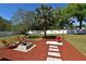Spacious backyard featuring a fire pit, grill, and a charming seating area, perfect for outdoor entertaining at 10 Lilac Dr, Debary, FL 32713