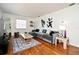 Cozy living room with a plush gray sofa, stylish rug, and hardwood floors, perfect for relaxation and entertaining at 10 Lilac Dr, Debary, FL 32713