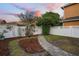 Landscaped backyard featuring a brick walkway, flower garden, privacy fence, and mature trees at 104 W Lake Victoria Cir, Deland, FL 32724