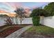 Landscaped backyard featuring a brick walkway, flower garden, privacy fence, and mature trees at 104 W Lake Victoria Cir, Deland, FL 32724