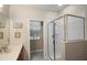 This bathroom features a glass-doored shower and vanity with neutral tones for a modern space at 104 W Lake Victoria Cir, Deland, FL 32724