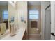 This bathroom features a shower with glass doors, vanity, window, and toilet for convenience at 104 W Lake Victoria Cir, Deland, FL 32724