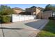 Rear exterior view with a paved driveway, basketball hoop, well-maintained landscaping, and a privacy fence at 104 W Lake Victoria Cir, Deland, FL 32724