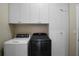 This laundry room contains a washer, dryer, overhead cabinets, and closet to keep tidy at 104 W Lake Victoria Cir, Deland, FL 32724