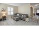 Cozy living room featuring a plush sectional sofa, tile floors, and plantation shutters at 104 W Lake Victoria Cir, Deland, FL 32724