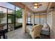 Enclosed patio with brick flooring, ceiling fan, and a comfortable seating area overlooking the manicured yard at 104 W Lake Victoria Cir, Deland, FL 32724