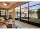 Screened patio with brick flooring, ceiling fan, and comfortable seating area overlooking the landscaped backyard at 104 W Lake Victoria Cir, Deland, FL 32724
