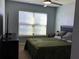 Cozy bedroom featuring a ceiling fan, a comfortable bed, and a window for plenty of natural light at 112 Grande Lake Dr, Daytona Beach, FL 32124