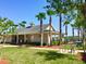 Community clubhouse with palm trees, lawn, and bike racks set against a clear blue sky at 112 Grande Lake Dr, Daytona Beach, FL 32124