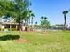 View of the neighborhood pool and lawn with palm trees set against a clear blue sky at 112 Grande Lake Dr, Daytona Beach, FL 32124