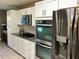 Bright kitchen features white cabinets, stainless steel appliances and a granite countertop at 112 Grande Lake Dr, Daytona Beach, FL 32124