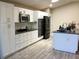Bright kitchen features white cabinets, stainless steel appliances and a granite countertop at 112 Grande Lake Dr, Daytona Beach, FL 32124