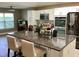 Open kitchen with stone countertops, stainless appliances, white cabinets and counter seating at 112 Grande Lake Dr, Daytona Beach, FL 32124