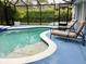 Inviting screened-in pool area with lounge chairs and lush landscaping for ultimate privacy at 112 Grande Lake Dr, Daytona Beach, FL 32124