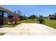 Serene backyard featuring a tiled patio, lush lawn, and views of natural greenery at 120 Black Duck Cir, Daytona Beach, FL 32119
