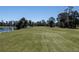 Beautiful golf course view with lush green grass, mature trees, and a serene pond on a sunny day at 120 Black Duck Cir, Daytona Beach, FL 32119