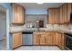 Well-lit kitchen with stainless steel appliances, wood cabinets, and stone countertops at 120 Black Duck Cir, Daytona Beach, FL 32119