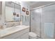 Bathroom with white vanity, framed mirror, a sliding glass door shower, and toilet at 120 Hibiscus Woods Ct # 14D, Deltona, FL 32725