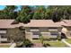 Two-story exterior featuring tan siding, shuttered windows, and a brown shingle roof at 120 Hibiscus Woods Ct # 14D, Deltona, FL 32725