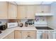 Kitchen with light wood cabinets, updated appliances, and neutral countertops at 120 Hibiscus Woods Ct # 14D, Deltona, FL 32725