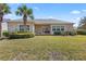 The home's backyard features a well-maintained lawn, mature trees, and a covered patio at 1205 Draycott St, Ormond Beach, FL 32174