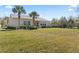Beautiful backyard with lush green lawn, tropical palm trees, and well-manicured shrubbery at 1205 Draycott St, Ormond Beach, FL 32174