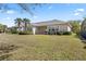 Expansive backyard featuring lush green grass, mature palm trees, and a cozy patio area perfect for outdoor living at 1205 Draycott St, Ormond Beach, FL 32174