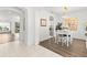 Open-concept dining area with wood floors, white furniture, and access to kitchen at 1205 Draycott St, Ormond Beach, FL 32174