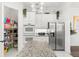 The bright kitchen is complete with stainless appliances, granite counters, white cabinets, and pantry at 1205 Draycott St, Ormond Beach, FL 32174